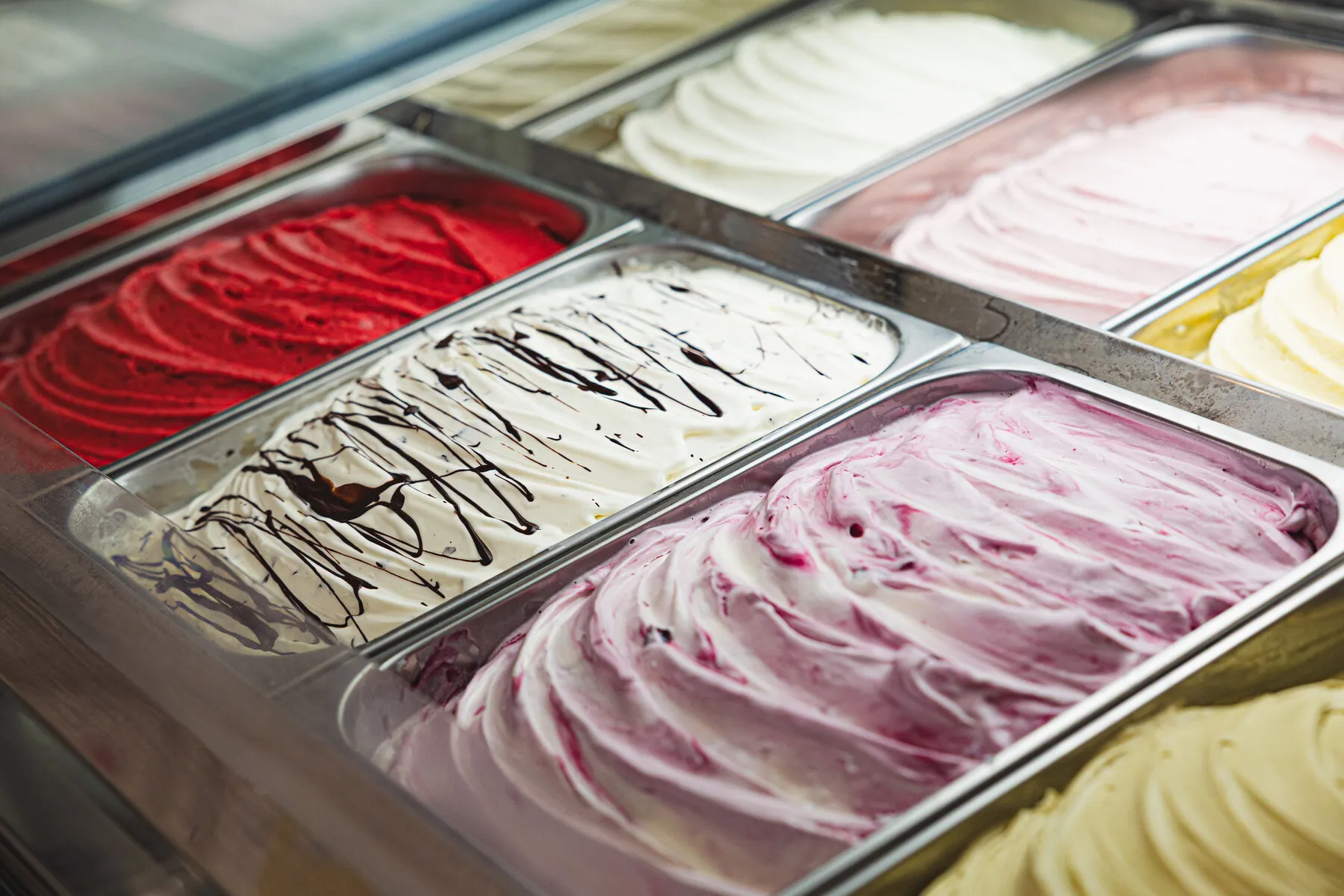 Trays of freshly churned gelato in the cabinet — strawberry, chocolate-rippled vanilla and wild berry, rippled by the spatula.